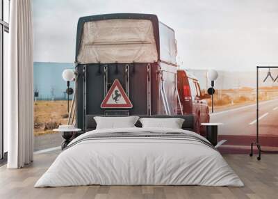 Car with a horse trailer on the road in Europe. Horse transport on the motorway. Wall mural