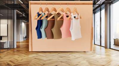 color basic undershirt clothes hanging on wooden hangers. fabric and textile close up on shirts with no sleeves. top crop shirt; Wall mural