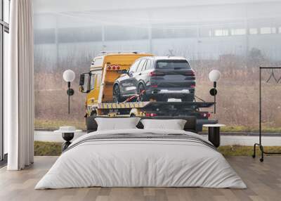 Flatbed towing truck with a car on the road. Roadside assistance. Car service transportation concept. Wall mural