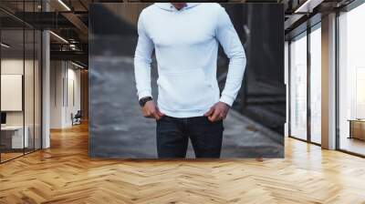 Man in white hoodie and jeans on urban street Wall mural