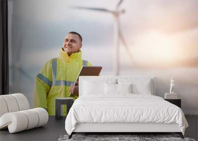 man working with tablet at a windmill farm generating electricity clean energy. man with a laptop with wind turbines background Wall mural