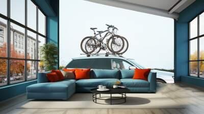 Outdoor Adventure Awaits. Family Car with Bicycles Mounted on Roof Rack. A vehicle with top mounted bikes. Wall mural