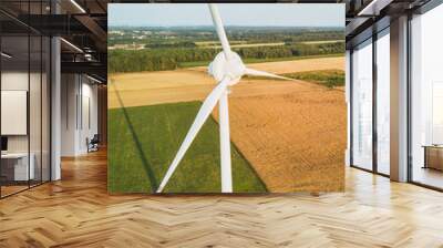 view of wind turbine among green fields and blue sky Wall mural