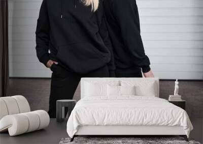 Woman and man wear black hoodie without a logo. No logo basic sportswear. Long sleeve sweatshirt mockup Wall mural