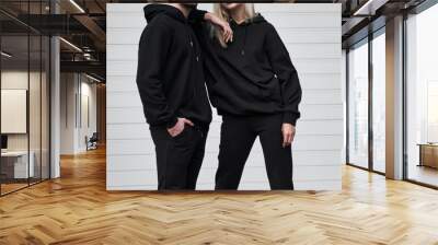 Woman and man wear black hoodie without a logo. No logo basic sportswear. Long sleeve sweatshirt mockup Wall mural