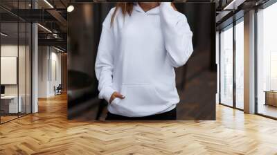 Woman Showcasing a white Hoodie for Logo Branding. Streetwear clothing mock-up. Logo on shirt template copy space. Wall mural