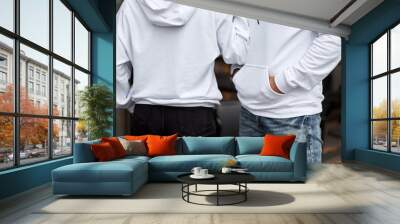 young couple wearing hoodie. man has white hoodie. girl has white hoodie Wall mural