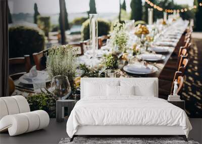 in the back yard of the old villa there is a long festive table, which is decorated with lemons and herbs, on the table are plates, glasses and candles. Wedding in Italy. Tuscany Wall mural