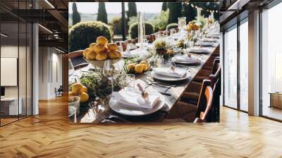 in the back yard of the old villa there is a long festive table, which is decorated with lemons and herbs, on the table are plates, glasses and candles. Wedding in Italy. Tuscany Wall mural