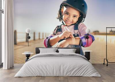 Skating injury, first aid or child portrait with bandage bruise from skate, cycling or accident in street. Happy, smile or girl with helmet for exercise, wellness health at beach, sea or ocean Wall mural