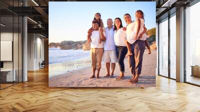 Travel, portrait and family at the beach at sunset, happy and relax while walking and bonding at the ocean together. Wellness, freedom and happy family enjoying a calm, relax walk on sea sand Wall mural