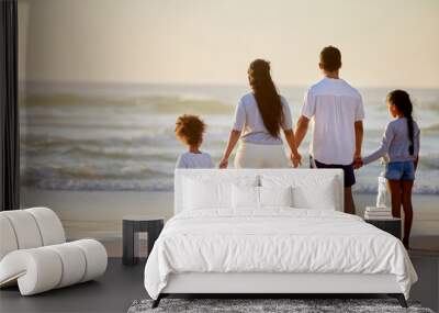 A happy family is but an earlier heaven. Shot of a family watching the sunset at the beach. Wall mural