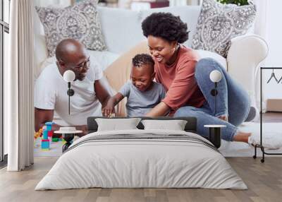 Building blocks, toys and black family playing on a living room floor happy, love and bonding in their home. Child development, learning and kid with parents in a lounge with alphabet, shape and game Wall mural