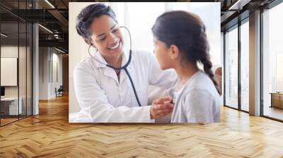 Doctor, cardiology and young child at a hospital and clinic for health consultation with a smile. Healthcare, wellness and pediatrician with kid listening to heart for medical consulting with expert Wall mural