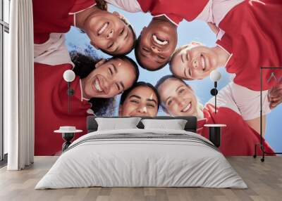 Female soccer team in a huddle smiling in unity and support in a circle. Below portrait of an active and diverse group of women football players or athletes happy and excited for a sports match Wall mural