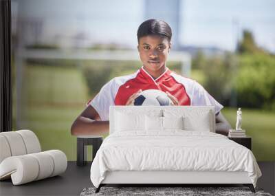 Soccer, football and sports with player, woman and athlete ready for a match, game or competition with ball on a pitch, field or stadium outdoor. Portrait of serious black female ready for training Wall mural