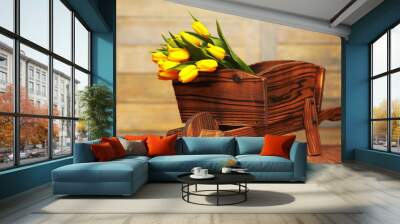 A bouquet of yellow tulips in a vase on the floor. A gift to a w Wall mural