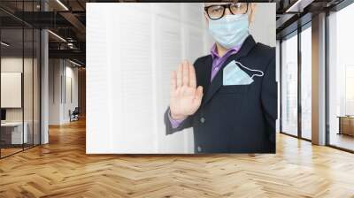 A disposable medical mask sticks out of a pocket instead of a napkin. A man with a disposable mask in a suit and jeans. Individual respiratory protection. Wall mural