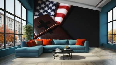 American flag and holy bible book on a mirror background. Symbol of the United States and religion. Bible and striped flag on a black background. Wall mural