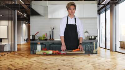 Asian cook in the kitchen prepares food in a cook suit Wall mural