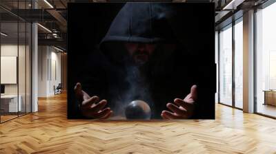 man in a black hood with cristal ball Wall mural