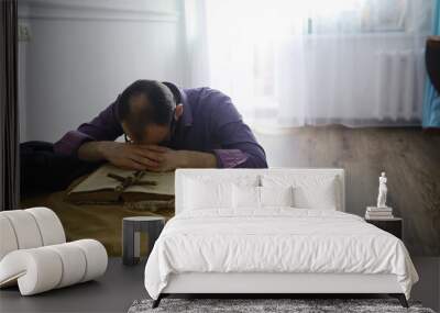 Man reading and pray from the holy bible near the bed in the evening. Christians and Bible study concept. Studying the Word Of God in church. Wall mural