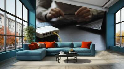 Modern dual band wireless router. Man working in the background. Fast and wireless internet concept. Wall mural