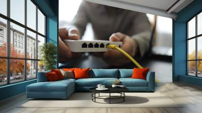 Modern dual band wireless router. Man working in the background. Fast and wireless internet concept. Wall mural