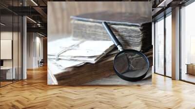 Old books on a wooden table and magnifier Wall mural