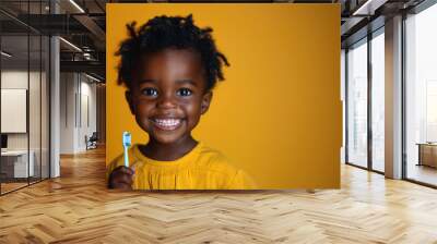 happy smile black kid boy child holds a toothbrush in hand on an orange isolated background. Pediatric dentistry for brushing teeth Wall mural