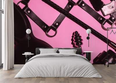 set of BDSM sex toys with handcuffs, whip flogger, butt anal plug for submission and domination on a pink background. Wide header cover for a horizontal banner for sex shop Wall mural