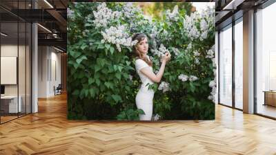 Attractive young  woman in lilac garden Wall mural