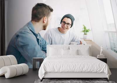 Men are sitting in front of the table near window Wall mural