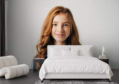 Red-haired pretty teenager girl smiling at the camera. Isolate on white background. Blue-eyed child with a benevolent emotion Wall mural