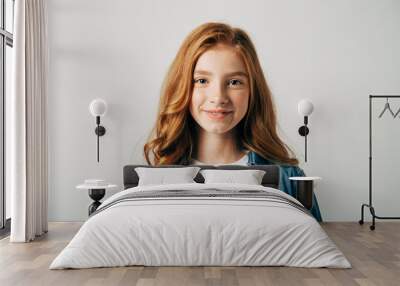 Red-haired pretty teenager girl smiling at the camera. Isolate on white background. Blue-eyed child with a benevolent emotion Wall mural