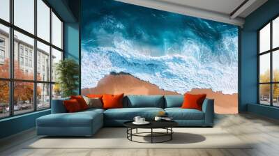 Aerial view of turquoise ocean waves meeting a remote sandy beach, creating foamy seascape Wall mural