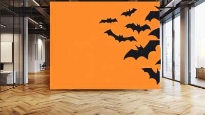 Black bats flying over an orange background for halloween Wall mural