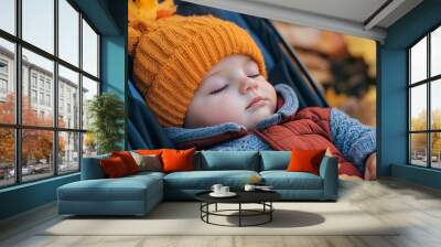 Peaceful baby boy snuggled up in stroller, surrounded by autumn leaves and warmth of cozy clothes Wall mural