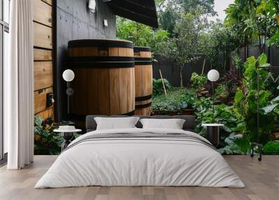 Two large wooden rainwater barrels in a lush green garden for harvesting Wall mural