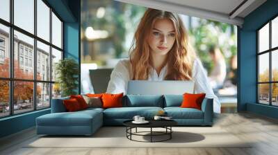 Young professional woman working on laptop in modern green office Wall mural