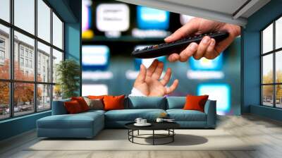 hand of child takes remote control of smart television from parent Wall mural