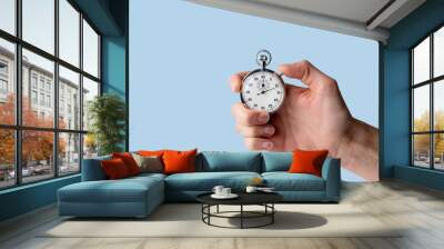 timer held in hand, blue background Wall mural