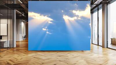 The sun's rays break through the blue clouds. The background of the sky. Wall mural