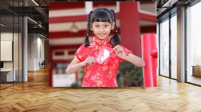 Beautiful asian girl holding ang pow or red packet monetary gift Wall mural