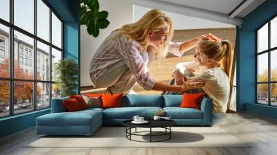 adorable woman and child girl sit talking on the floor at home, cute mother and daughter have talk, smile, get support Wall mural