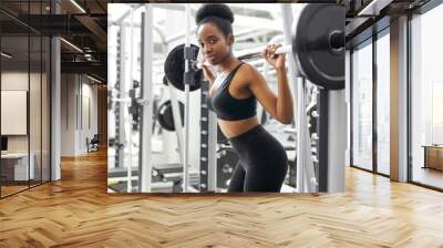 athletic african woman warming up doing weighted lunges with barbells, exercise for butt legs at gym, healthy lifestyle sport bodybuilding concept Wall mural