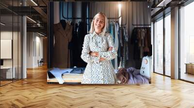 Beautiful caucasian fashion designer stand and happily smile at workplace, look at camera. Dressed in white dress. Background design studio Wall mural