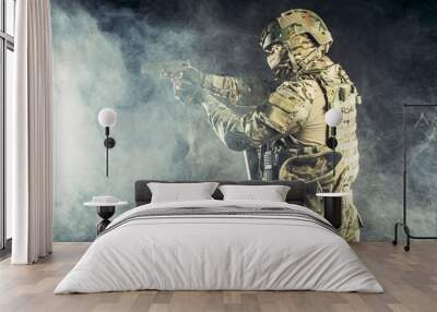 brave strong and confident man soldier wearing army clothes, green camouflage stand holding gun, ready to shoot Wall mural