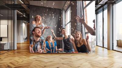 Cheerful group of friends having fun at home,eating popcorn and enjoying together. Wall mural