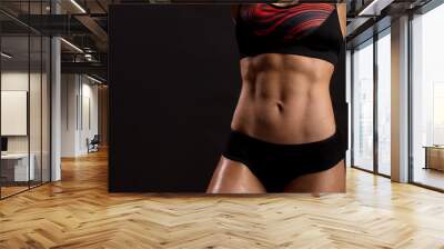 Close up of fit female abs isolated on black background with copy space. Fitness female and trained stomach, Perfect Slim Body. Sport, Bodybuilding, Fitness Concept Wall mural